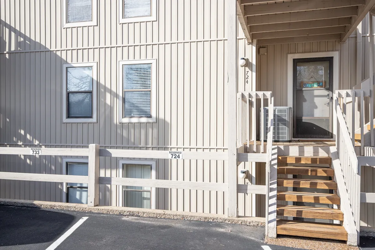 This image captures the exterior entrance to the condo units, featuring a staircase leading up to numbered doors and inviting front stoops. The area is cozy and well-kept, suggesting a sense of welcome and security. The scene hints at the transition from arrival to entry, setting the stage for a convenient and reassuring guest experience.